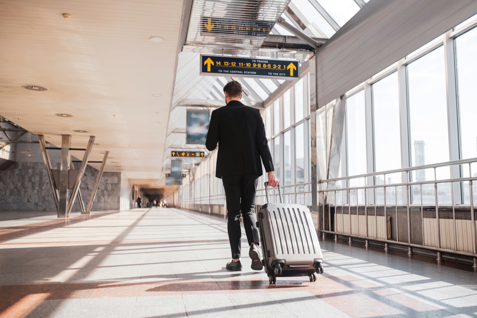 Solo-reiziger met trolley-koffer in een luchthaventerminal, het profiel dat Skiplagged het best bedient